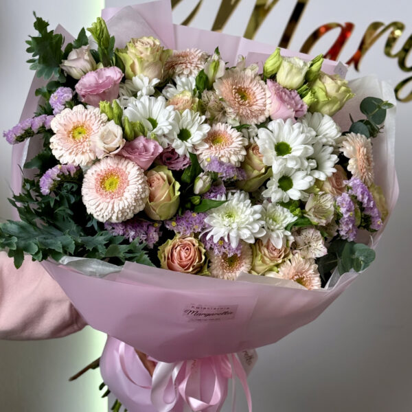 Bukiet skomponowany z gerber, róż oraz margaretek w pudrowych odcieniach różu, lawendy i kremu